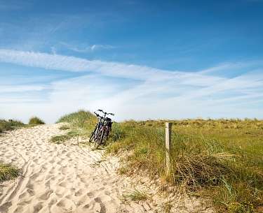 Zwei Räder stehen am Rande einer Düne nahe des Radhotels 