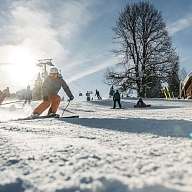 Eine Gruppe Skifahrer fährt im Schneeurlaub die Piste hinunter 